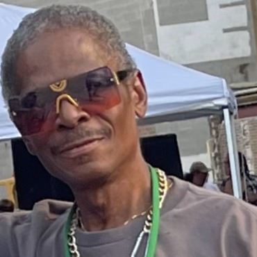 Black man with mustache and short gray hair, wearing sunglasses.