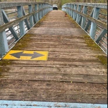 A photo of the blue bridge along Battle Creek Linear Park, near the Kalamazoo River.