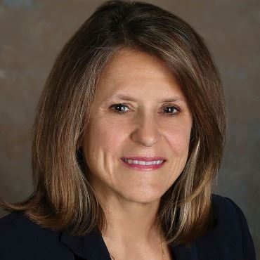Portrait of a white woman with shoulder-length brown hair.