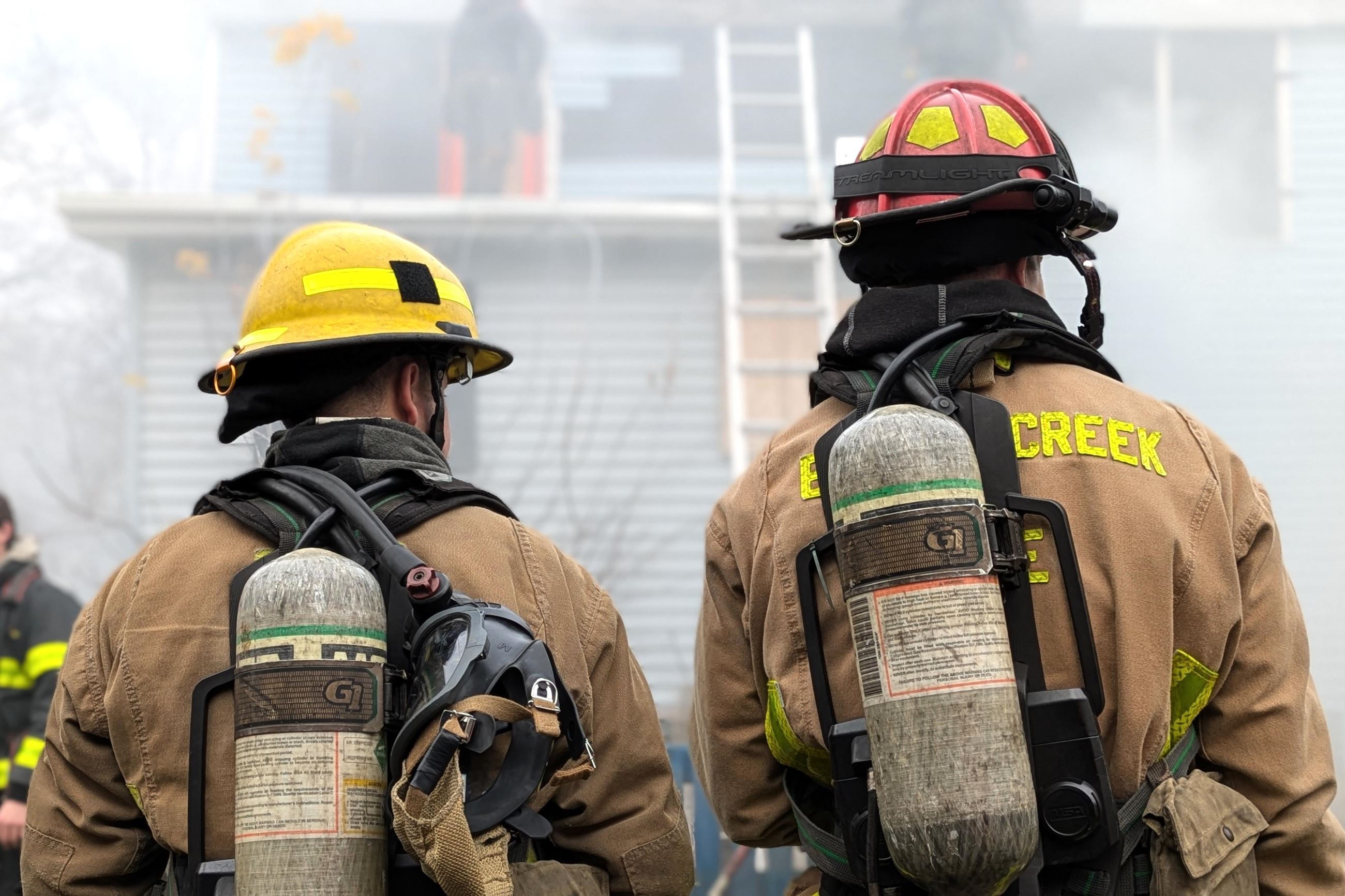 BCFD Behind the Door training picturing two firefighters standing with their backs to the camera.
