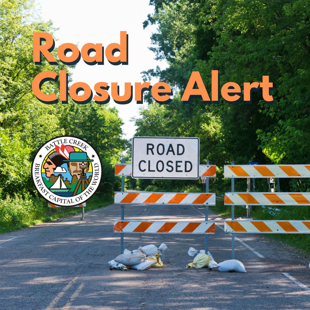 A photo of a road closed off with barricades that reads, 